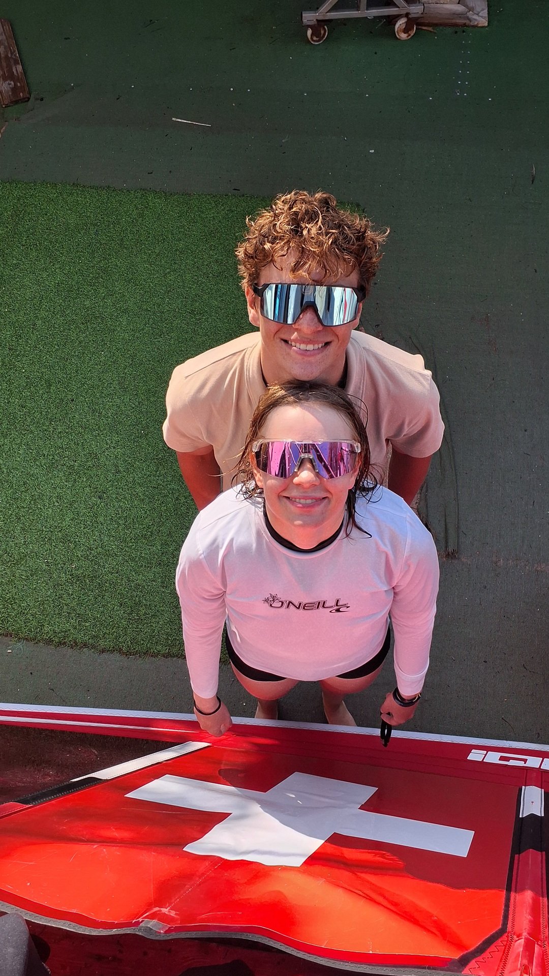 Roger and Chloé Favre beside their windsurfing equipment with the Swiss flag